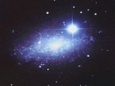petite galaxie dans le Lion, visible au loin derrire une toile proche. L'effet cruciforme est d  l'optique